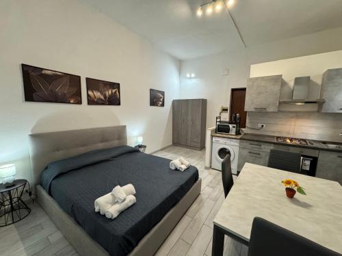 a bedroom with a bed and a table and a kitchen at Civico 10 II in Sassari
