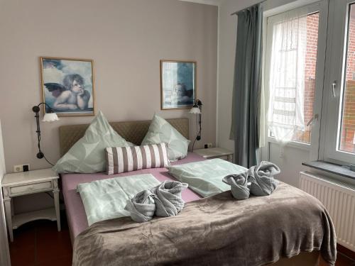 ein Schlafzimmer mit einem Bett mit Schuhen drauf in der Unterkunft Aparthotel Domizil in Borkum