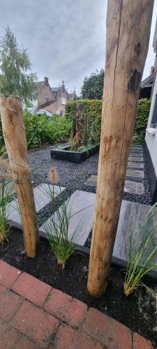 two wooden posts in a garden with plants at Tip Top Studio Vlissingen in Vlissingen