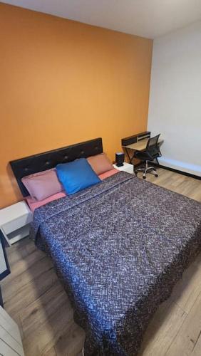 um quarto com uma cama com almofadas coloridas em Maisonnette Proche plage em Brest