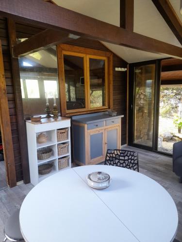 - une cuisine avec une table blanche et quelques fenêtres dans l'établissement Chalet Dominique, à Azzana