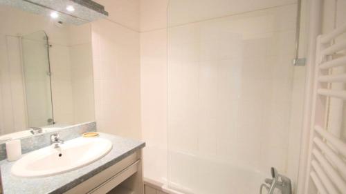 une salle de bain blanche avec un lavabo et une douche dans l'établissement Résidence Parc Aux Etoiles - C307PAE - APPARTEMENT 2 CHAMBRES AVEC BALCON MAE-8724, à Narreyroux