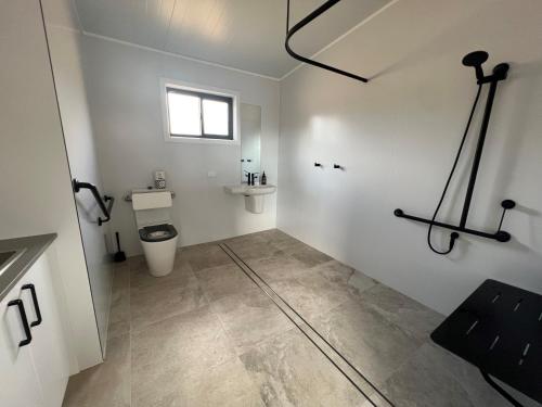 a bathroom with a toilet and a sink at Hygge Eco Cabins in Jindabyne