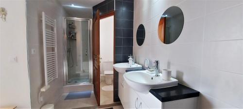 ein weißes Bad mit 2 Waschbecken und einer Dusche in der Unterkunft Cosy marina moderne et spacieuse in Aigues-Mortes