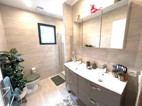een badkamer met een wastafel, een toilet en een spiegel bij Appartement La Grande-Motte, 4 pièces, 6 personnes - FR-1-716-63 in La Grande-Motte