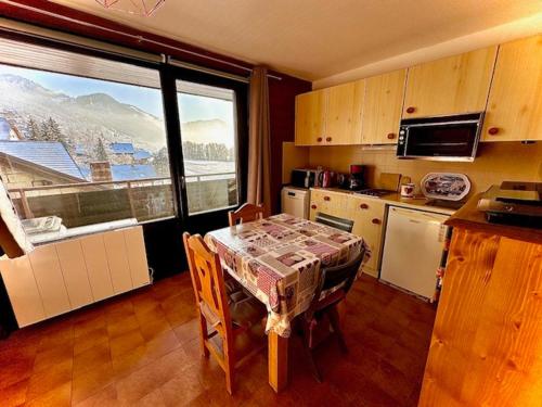 - une cuisine avec une table et une vue sur la montagne dans l'établissement Charmant studio au cœur du village avec balcon, idéal pour 2-3 pers, proche commodités ! - FR-1-692-96, à La Chapelle-dʼAbondance