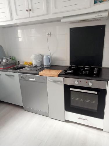 une cuisine avec des armoires blanches et un four à plaques de cuisson dans l'établissement Appartement Montpellier Sud 3 pièces, à Montpellier