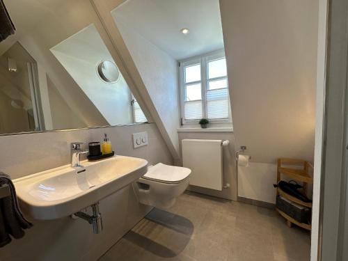 ein Badezimmer mit einem Waschbecken, einem WC und einem Spiegel in der Unterkunft Wohnen auf der historischen Stadtmauer im Herzen von Detmold in Detmold