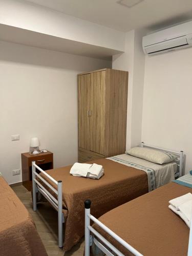 a room with two beds and a cabinet at Scopello Guidaloca Villas in Scopello