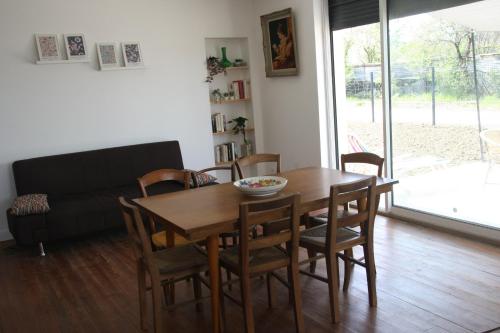 un salon avec une table et des chaises en bois dans l'établissement GITE chez mamie - 7 personnes A SAINTE LIVRADE SUR LOT, à Sainte-Livrade-sur-Lot