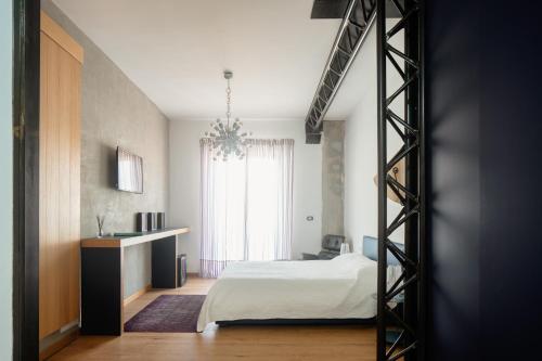 a bedroom with a bed and a desk and a window at Casa Rebecca in Riposto