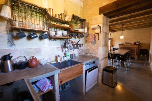uma cozinha com um lavatório e um fogão forno superior em Domaine De Chantemerle B'nB em Marsac