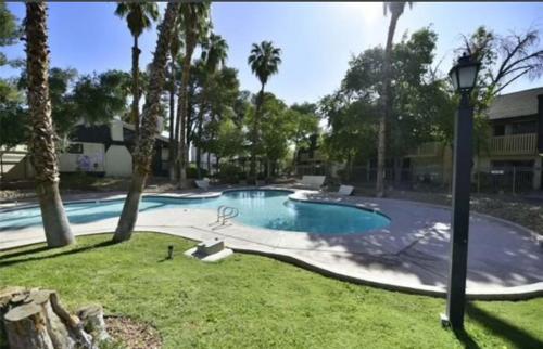 - une piscine dans une cour avec des palmiers dans l'établissement Strip, à Las Vegas