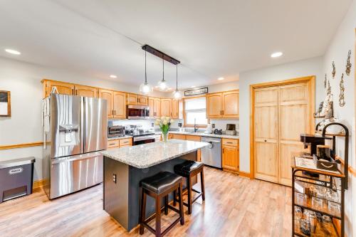 a kitchen with wooden cabinets and stainless steel appliances at Pet-Friendly Pocono Lake Home with Private Hot Tub! in Pocono Lake