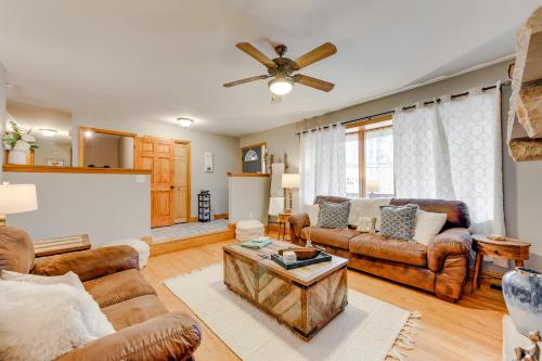a living room with leather furniture and a ceiling fan at Pet-Friendly Pocono Lake Home with Private Hot Tub! in Pocono Lake