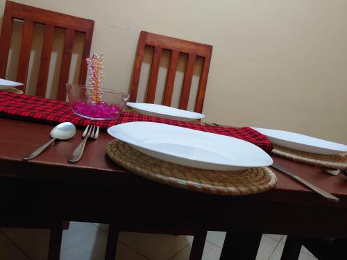 een tafel met borden en bestek erop bij Kili House Hostel in Arusha