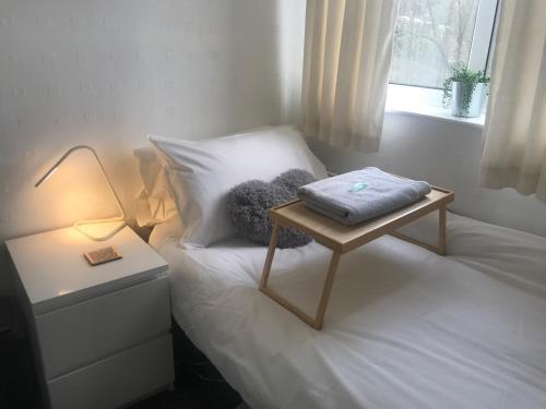 Un pequeño dormitorio con una cama con una mesa. en fAiRy Dell Guesthouse with cozy lockable rooms, tv, free tea tray, free wifi, free parking, en Oakenshaw