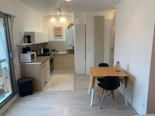 une cuisine avec une table et des chaises ainsi qu'une salle à manger dans l'établissement Studio 27m² - centre-ville - parking privé - Tt équipée - 1km Gare TGV, au Pouliguen