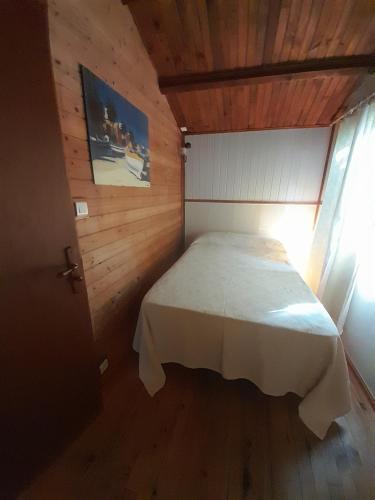 a bedroom with a white bed in a wooden room at Chalet Dominique 