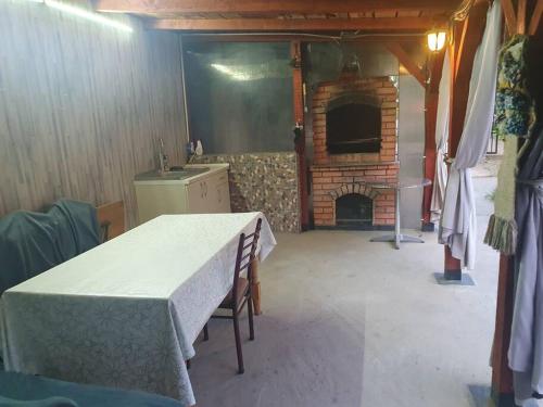 een keuken met een tafel en een bakstenen oven bij Casa cu Nuc in Bordeiu