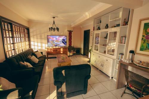 a living room with a couch and a tv at Pousada Café in Torres