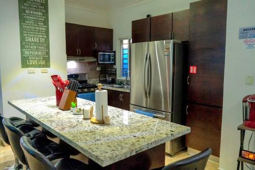 a kitchen with a counter with a stainless steel refrigerator at LaPileta809 in La Romana