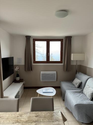 a living room with a couch and a table at 2 pièces, au pied des pistes ds Résidence Gd Hôtel in Valberg