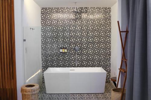 ein Badezimmer mit einem weißen Waschbecken und einer Fliesenwand in der Unterkunft Hotel Boutique Casa de Arte Oaxaca, Art Gallery & Pool in Oaxaca de Juárez