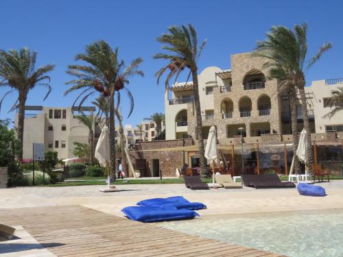 a resort with palm trees and a swimming pool at Azzurra two-Bedroom Apartment at Sahl Hasheesh in Hurghada