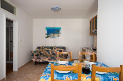 a dining room with a table and a couch at Sunny Adriatic apartments Valentin in Vrsar