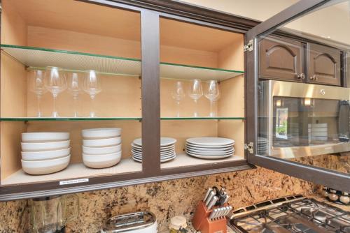 a kitchen cabinet filled with plates and glasses at Tropical Escape Pool Jacuzzi Bar in Alvin TX in Alvin