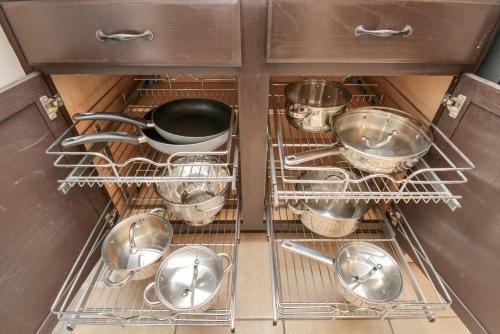 a drawer filled with pots and pans in a kitchen at Tropical Escape Pool Jacuzzi Bar in Alvin TX in Alvin