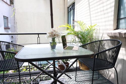 una mesa con un jarrón de flores en el balcón en Casa Pánuco en Ciudad de México