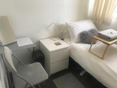 a small room with a bed with a desk and a chair at fAiRy Dell Guesthouse with cozy lockable rooms, tv, free tea tray, wifi & parking in Oakenshaw