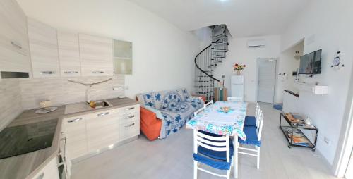 a kitchen with a table and a dining room at FollowTheSun- Camera Fronte mare in Portoscuso