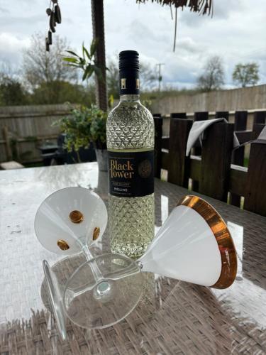 una botella de vino encima de una mesa en Bridie -rose Sleeps 4 to 6 with hot tub at extra cost en Kington