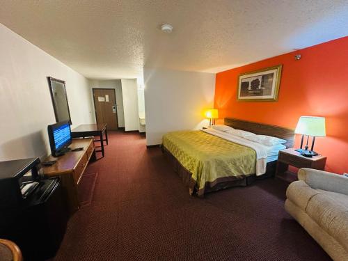 a hotel room with a bed and a flat screen tv at Studio 7 on Main in West Fargo