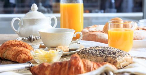 a table with a breakfast of pastries and orange juice at Porta Mazzini Central Rooms in Bagnacavallo