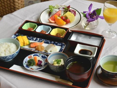 久留米市にあるSuikoyen Hotel - Vacation STAY 53761vの食べ物と飲み物が載った3つのトレイが置かれたテーブル