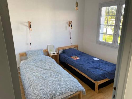 une chambre avec deux lits et une fenêtre dans l'établissement Maison de vacances,L'Epine, 4 chambres, 8 couchages, à LʼÉpine
