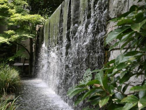 a waterfall on a stone wall with plants at Suikoyen Hotel - Vacation STAY 53800v in Kurume