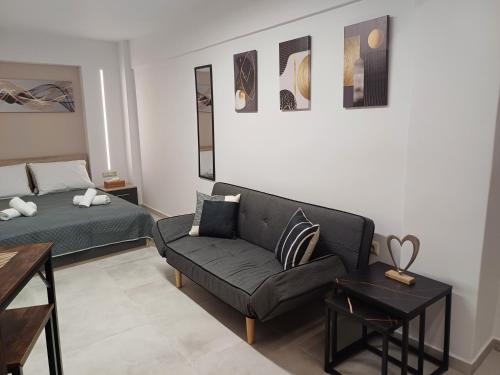 a living room with a couch and a bed at DUOMO City Center Suites in Heraklio Town