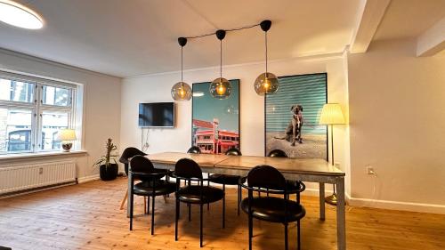 a dining room with a large wooden table and chairs at Fabelagtig lejlighed RA7 in Copenhagen