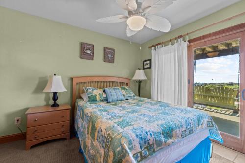 1 dormitorio con 1 cama, ventilador de techo y ventana en 5711 - OBX Ta SEA by Resort Realty, en Nags Head