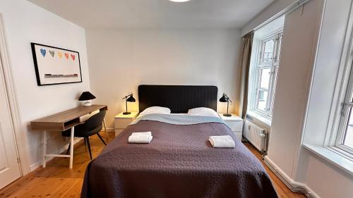 a bedroom with a large bed and a desk at Central apartment - RAP 7 in Copenhagen