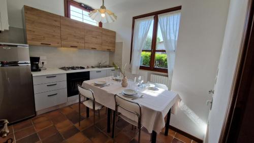 cocina con mesa con sillas y mantel blanco en Elisa Holidays Apartments, en Puegnago sul Garda