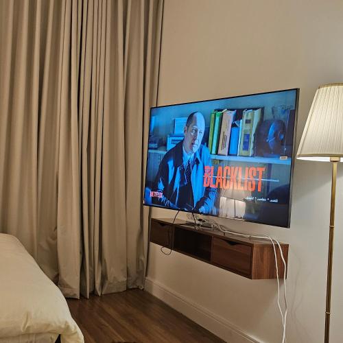 a flat screen tv on a wall in a bedroom at استديو. الياسمين للإيجار اليومي و دخول ذاتي. in Riyadh
