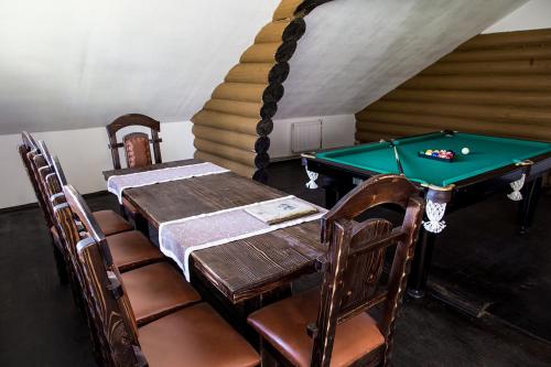a room with a pool table and chairs and a staircase at Hotel Krakow in Kyiv