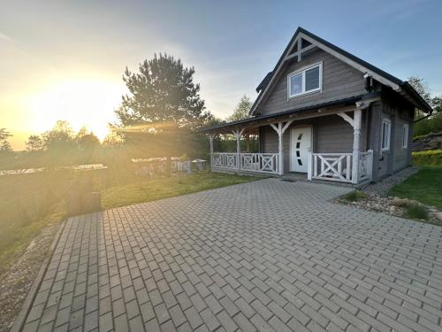 a house with a brick driveway in front of it at Dom z bala balia in Biskupiec