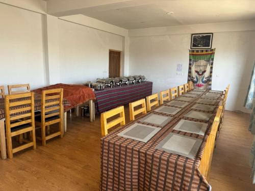 a room with a group of chairs and a stove at Mangyul guest house in Leh